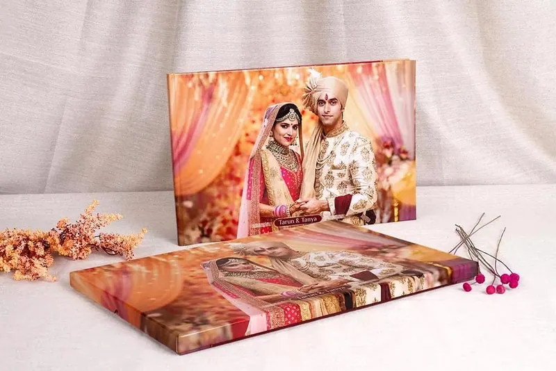 Printed wedding album and a canvas print of a couple in red and ivory wedding outfits