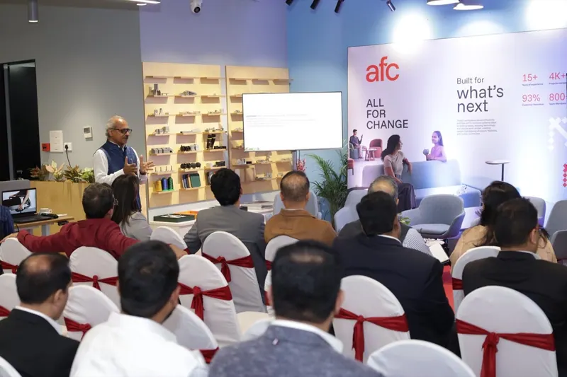 Speaker addressing a seated audience in a bright event space