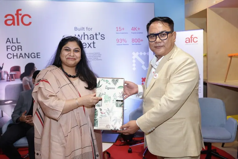 Two executives presenting a framed award on stage at a corporate event