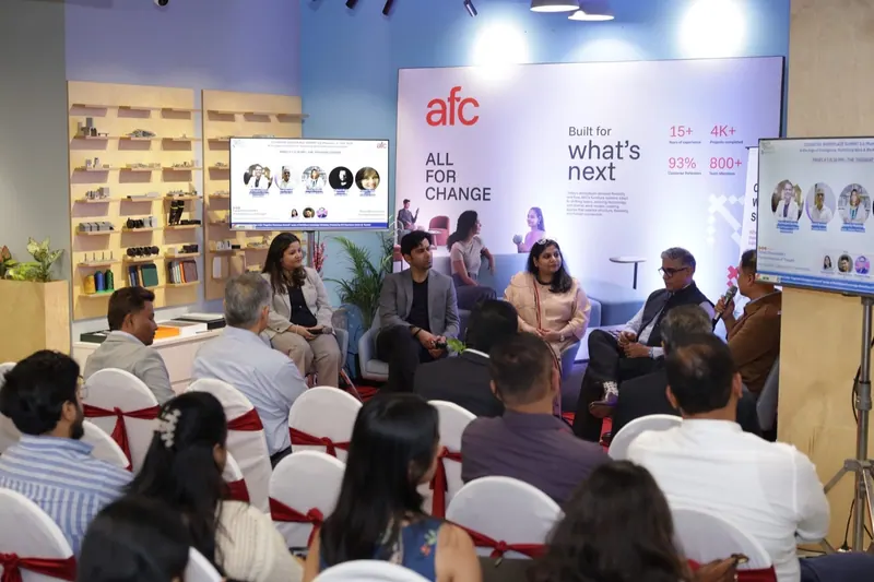 Panel discussion on a stage in front of a seated audience at a corporate launch event
