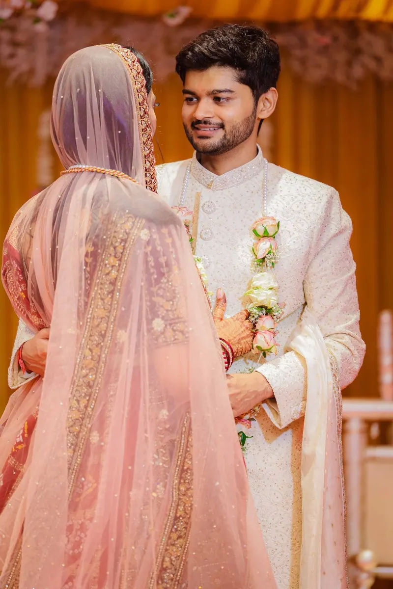 Groom smiling at the veiled bride during the ceremony