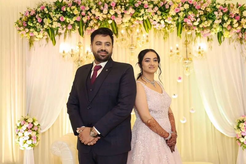 Couple back to back under a floral arch