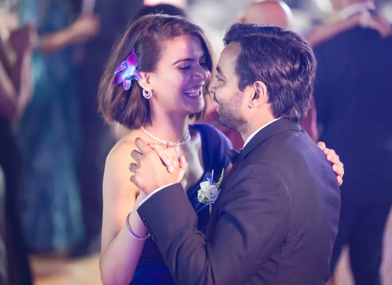 Father and daughter dancing and laughing at a celebration